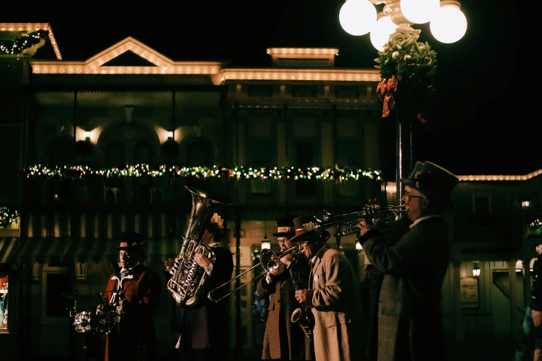 musicians performing at night with lit decorations in the background