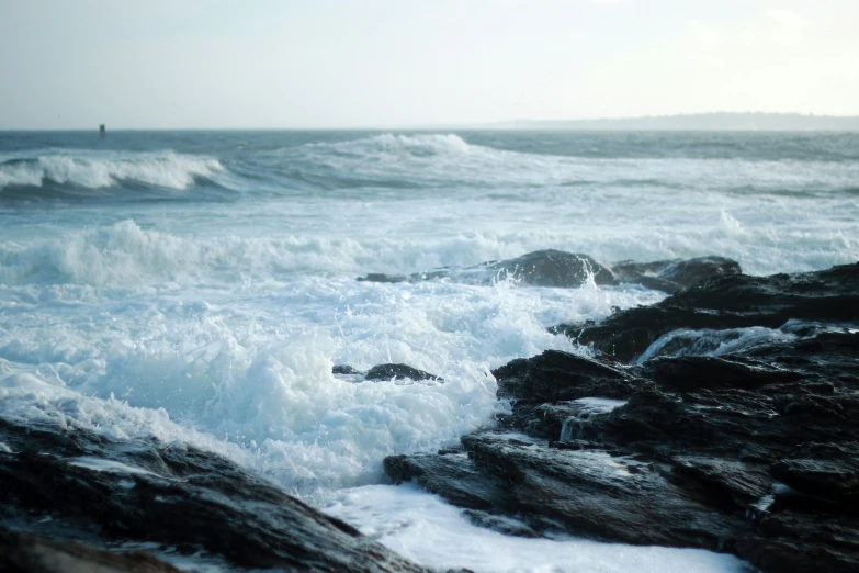 waves crash against rocks along the ocean shore