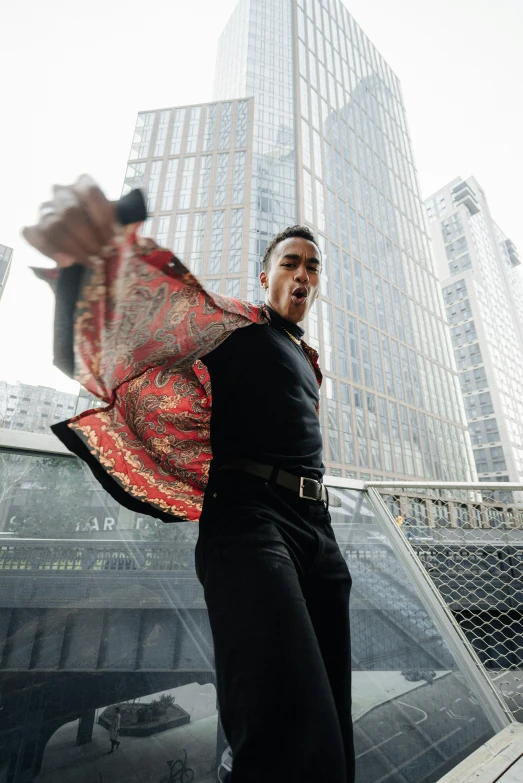 a young man holding an umbrella standing next to a building