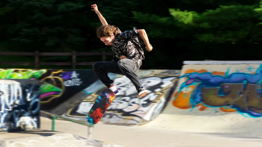 a man jumping in the air on his skateboard at a skate park