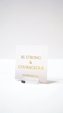 the back end of a card on a table that says be strong and courageous