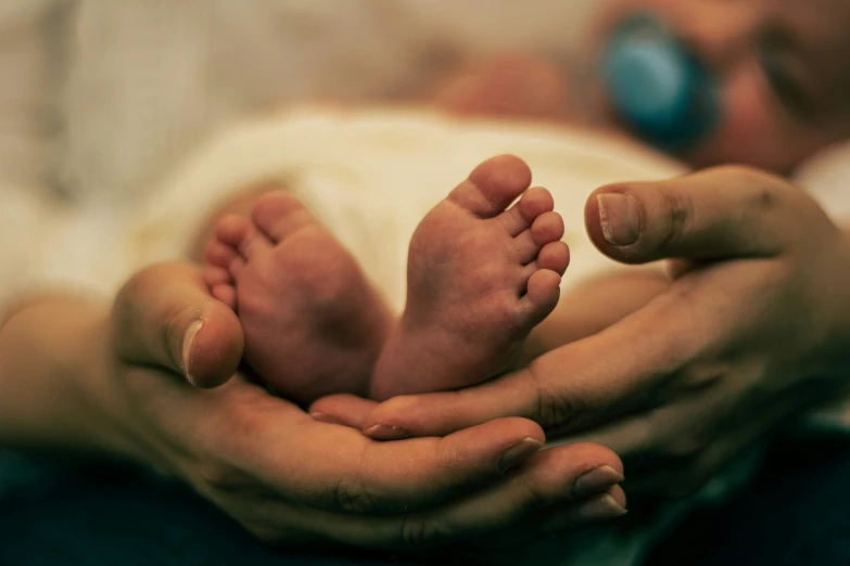 a person holds their baby in the arms of their hands