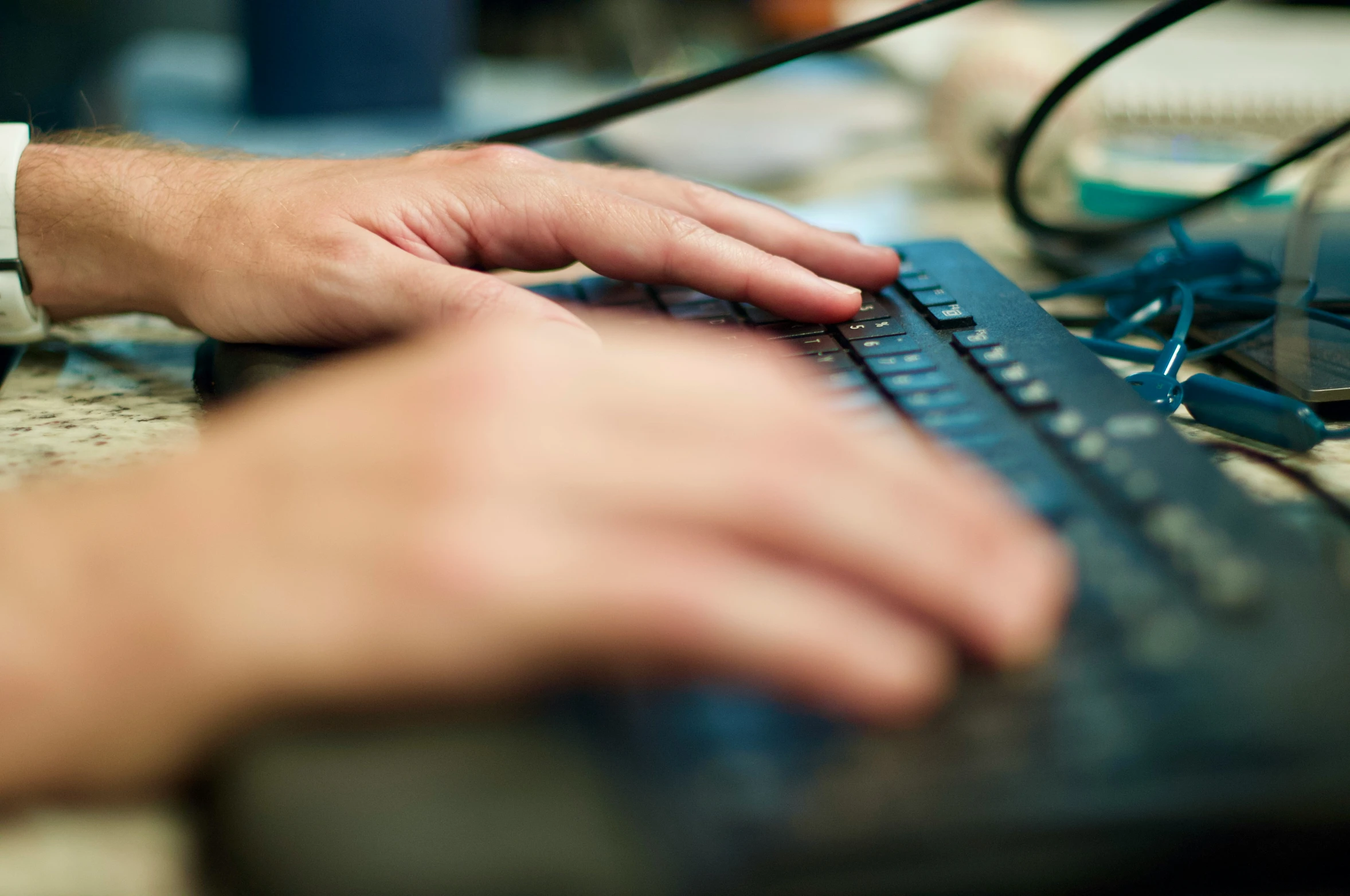 a person using a keyboard near a table