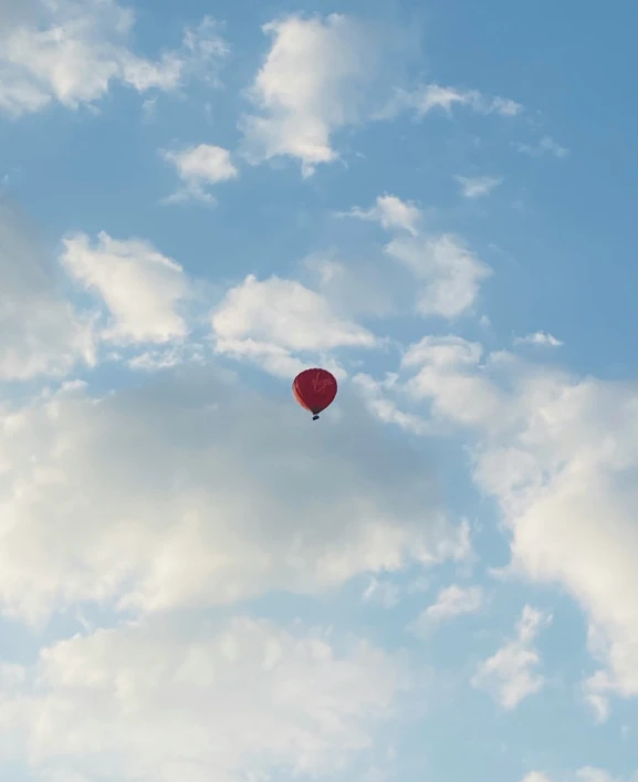 a balloon is flying through the sky with clouds