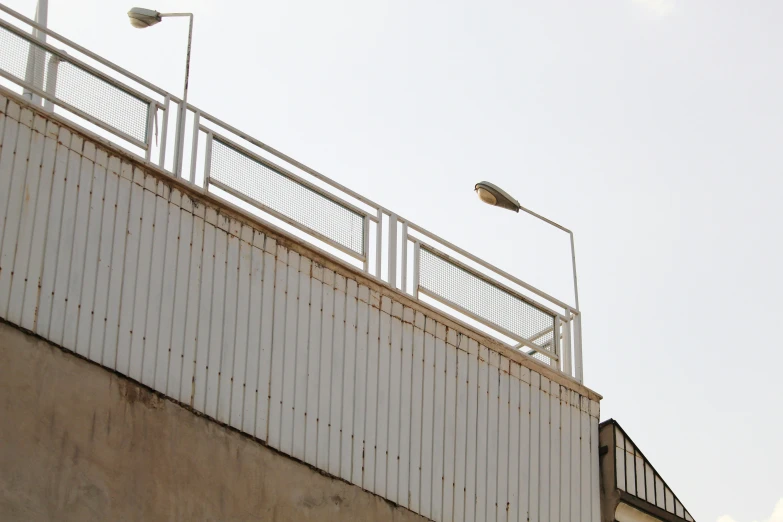 a wall and two street lights at an intersection