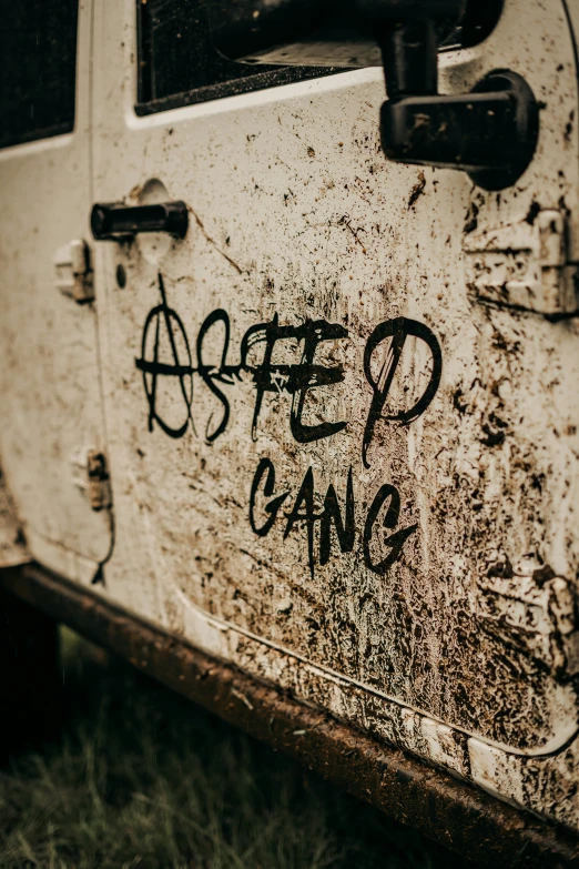 a dirty van with black graffiti on it