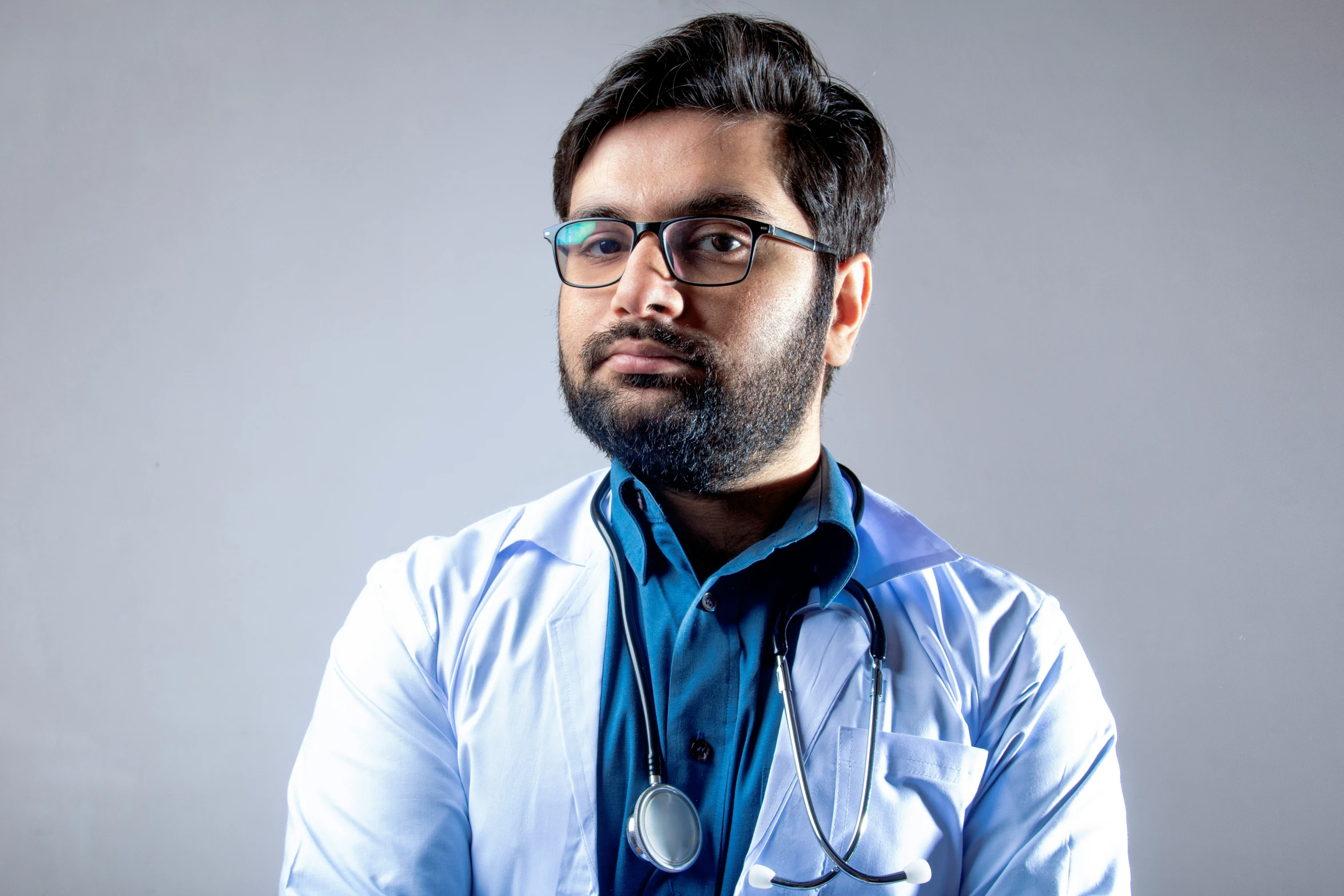 a person in a white shirt and glasses wearing a stethoscope