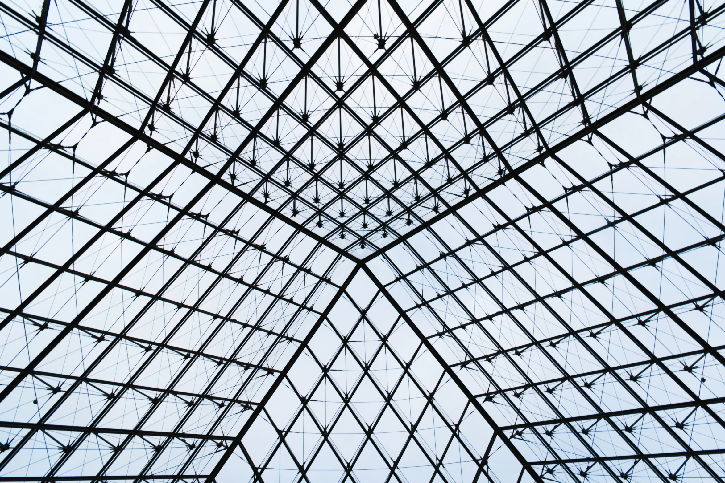 looking up at an ornate glass building with lots of electrical lines