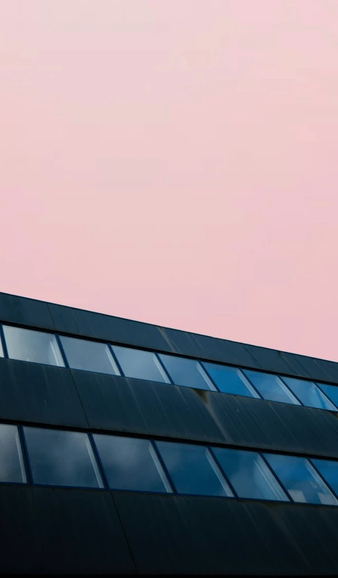 a red and blue airplane is flying near a building