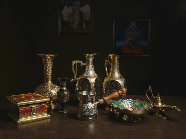 gold vases sitting on top of a wooden table