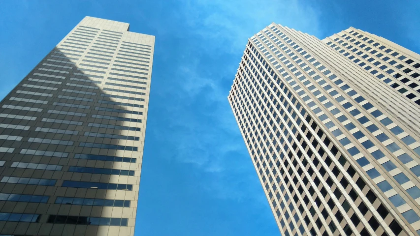 the view looking up at tall skyscrs from ground level