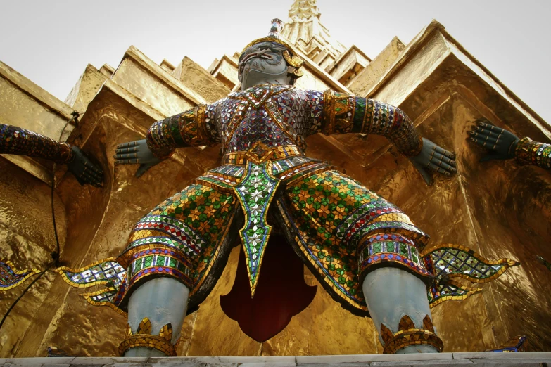 the large statue is painted gold and has many colors