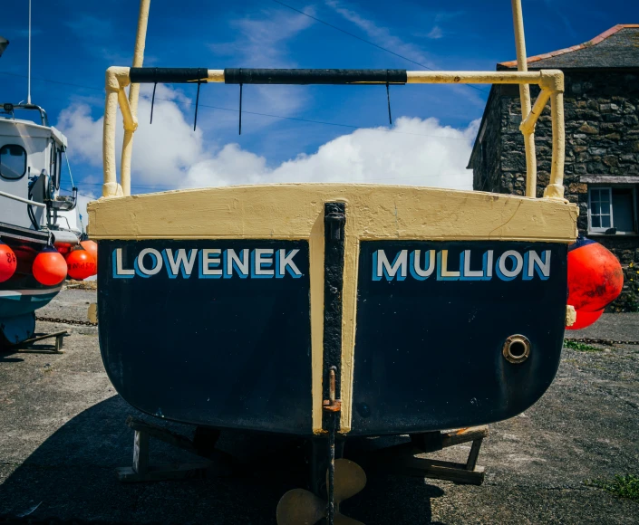 a rowboat on land in a parking lot