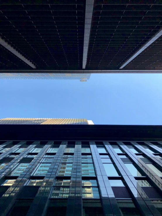 an image looking up at skyscrs from the ground