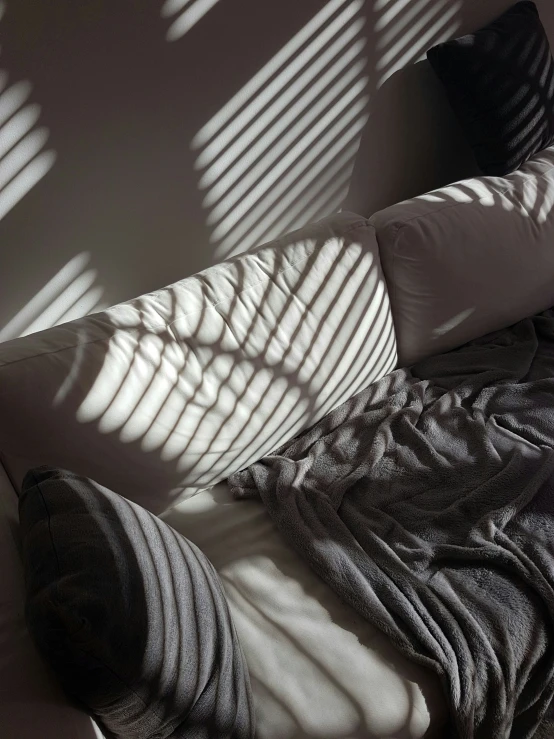 a bed with a blanket that has a person laying down on it