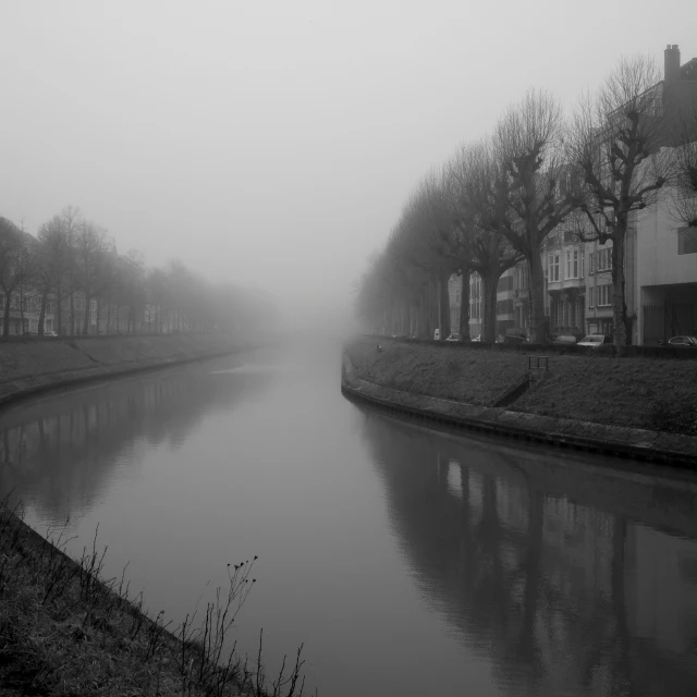 a black and white po of a canal with a train coming down it