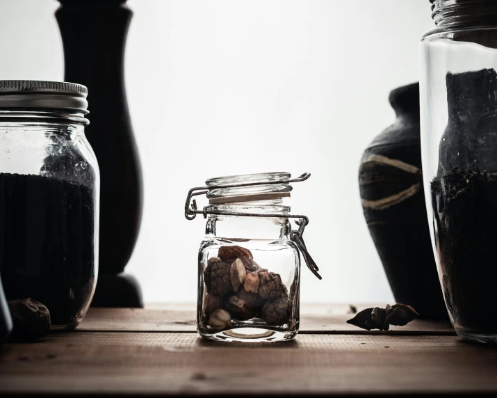 two jars with glass lids are next to each other