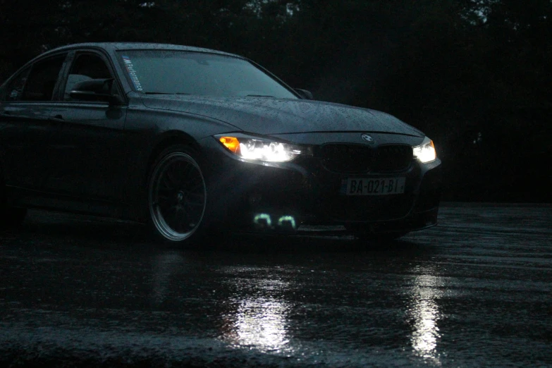 a bmw in the rain at night on a street