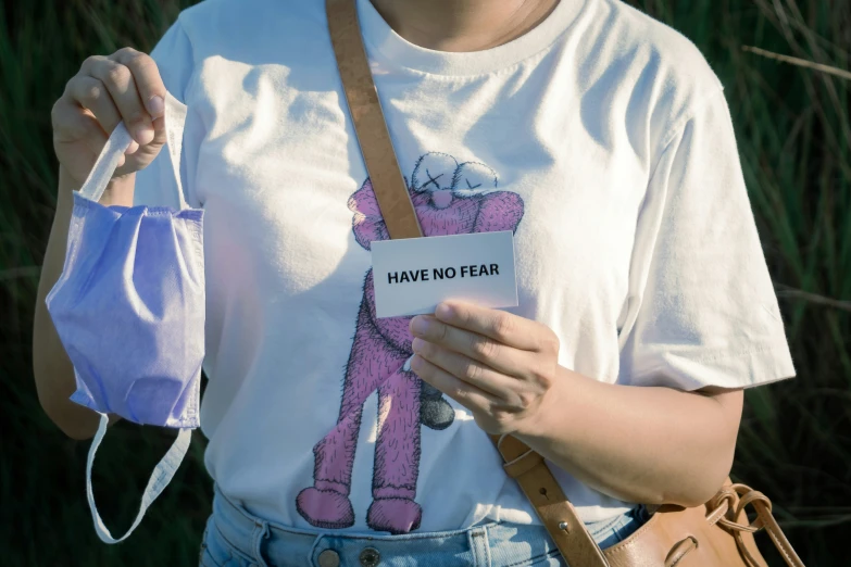 a woman with a pink bear on her shirt holds a purse