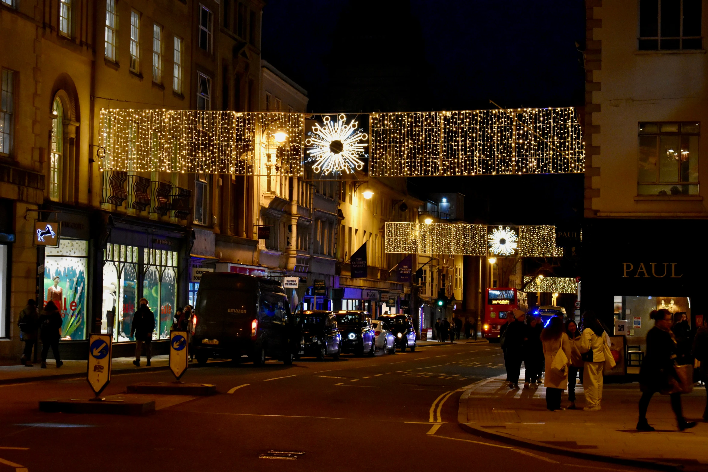 a street with lots of lights on it and people walking by