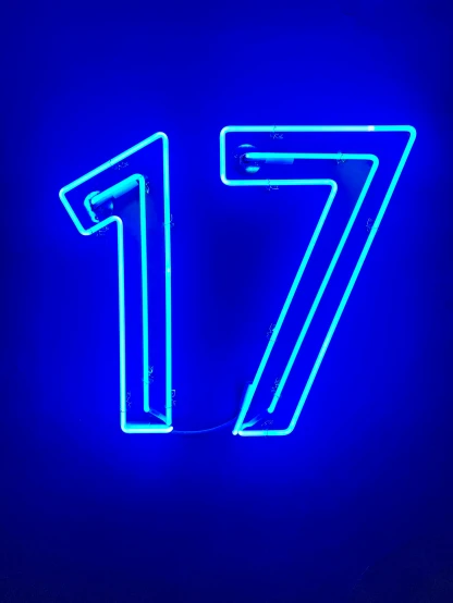 a neon blue number seven sign on a dark wall