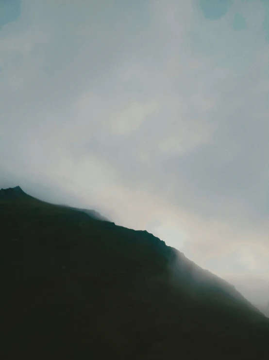 a mountain side with clouds moving through