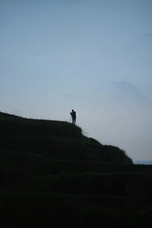 two people standing on a hill with one walking up it