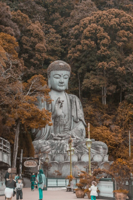 people and an oriental statue sit next to each other