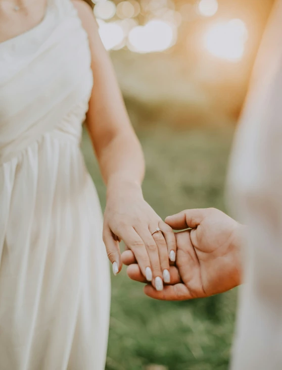 couple holding hands outside near each other