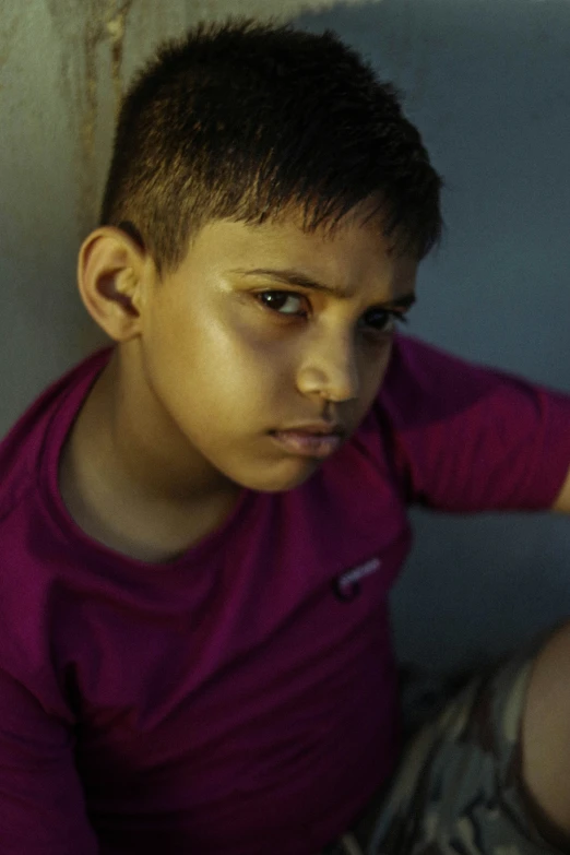 boy looking intently with his eyes open while sitting down