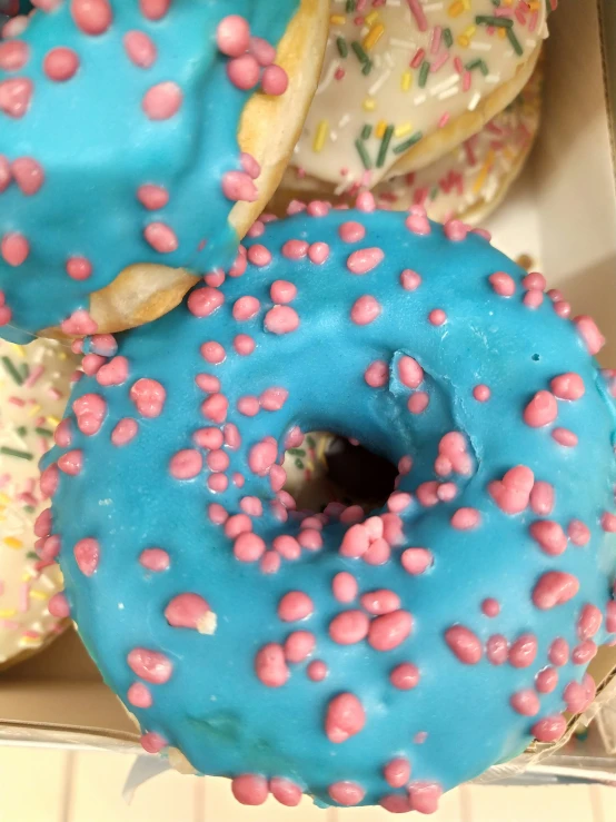 blue and pink donuts with sprinkles in a box