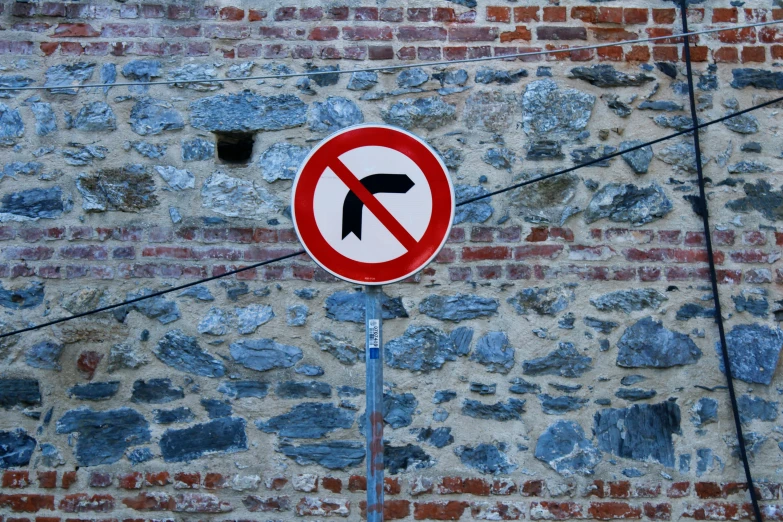 a no u - turn sign against a wall with no left turns