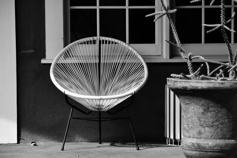 a white chair sits in front of some windows