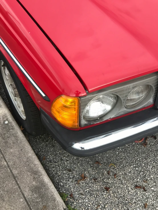 a red car is parked on the cement