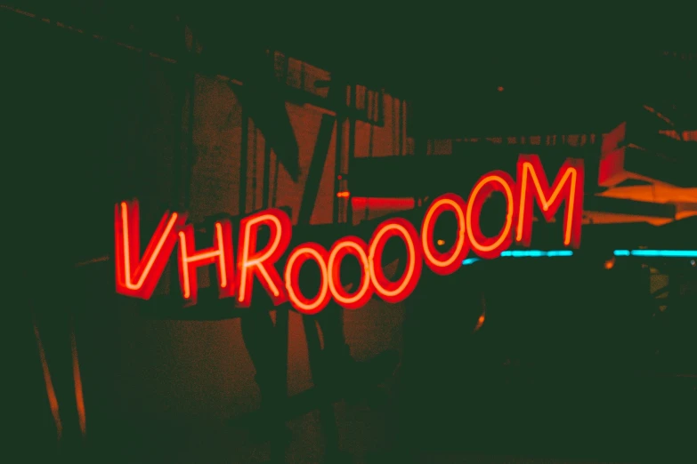 a close up of a red neon sign reading vroom