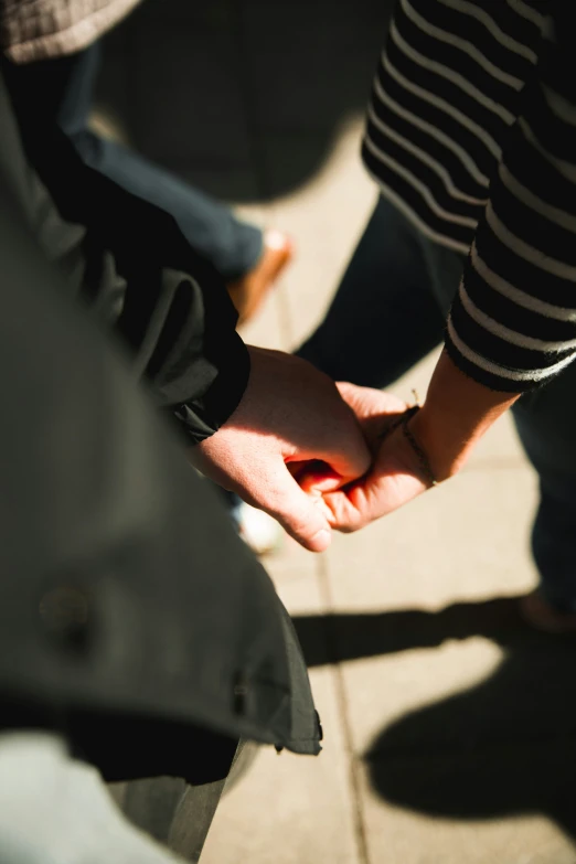 two people holding hands as they stand together
