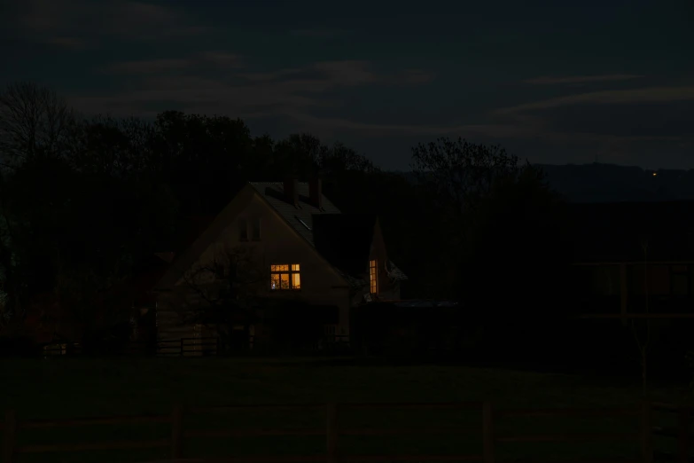 the house is lit up at night near the mountains