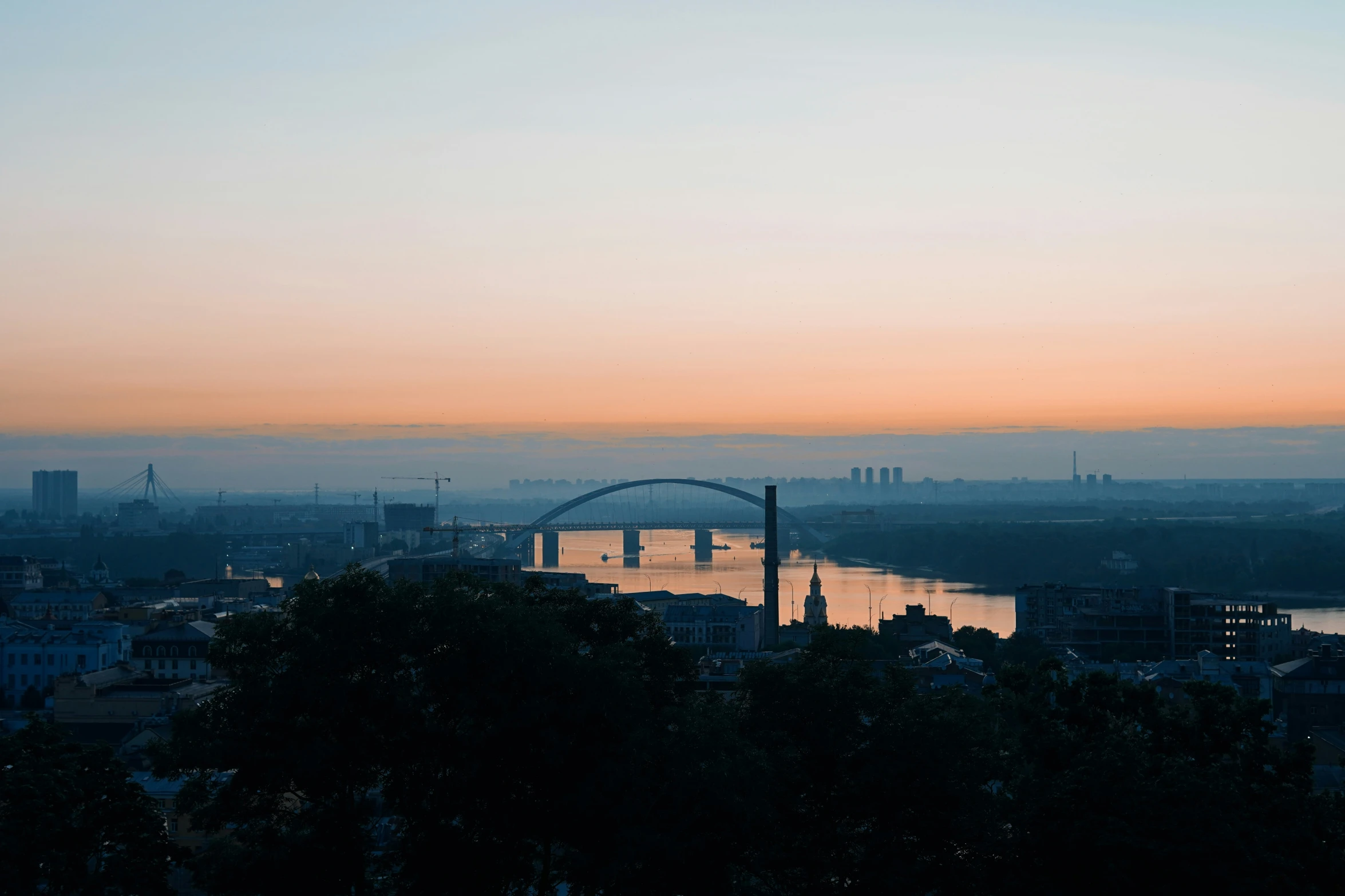 a city skyline as the sun sets in the distance