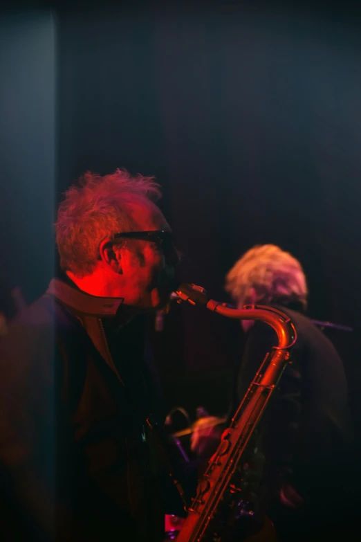 a man with grey hair playing a saxophone