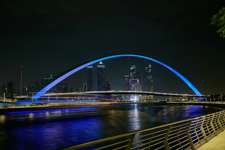 a large blue bridge spanning a river in a city