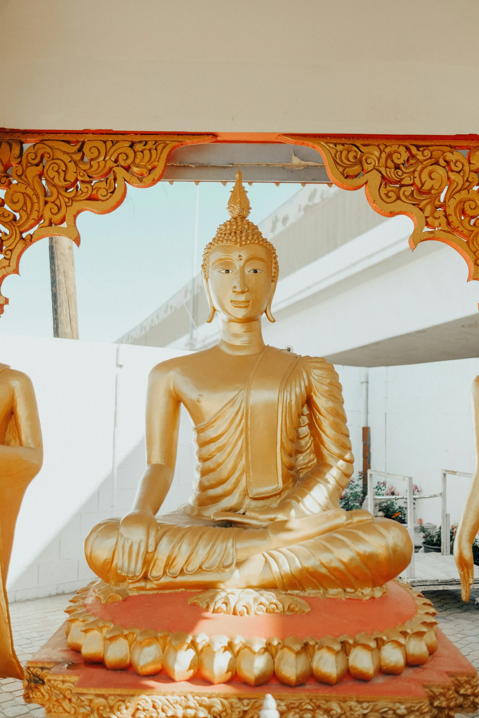 golden buddha statue sitting under a gilded frame