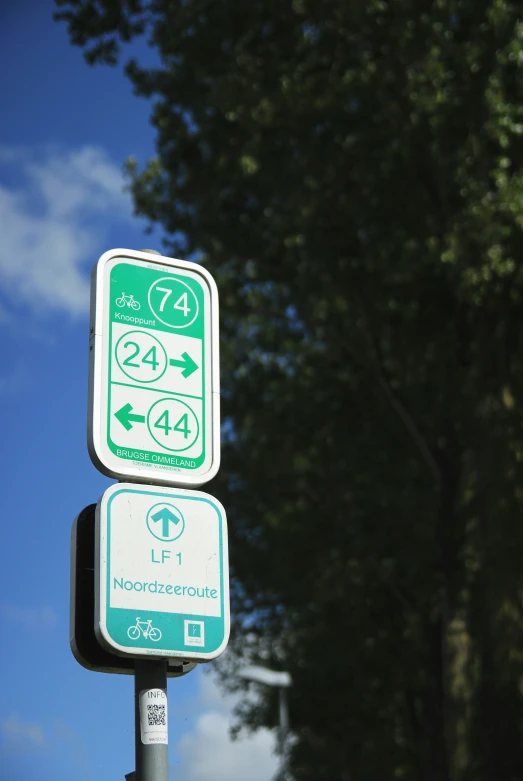 street signs at a bus stop with trees in the background