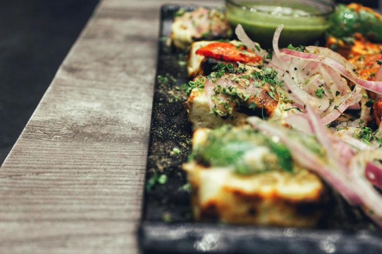 a black plate topped with food on top of a table