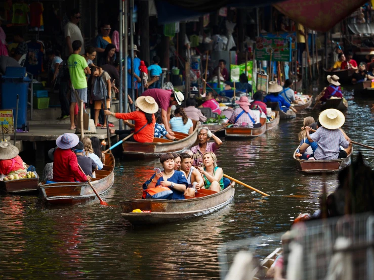 small boats with people in them sailing down a river