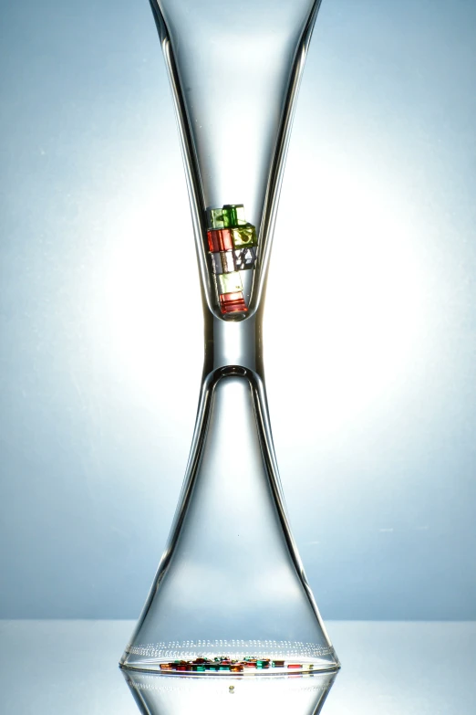 a large tall glass vase that has colorful objects in it