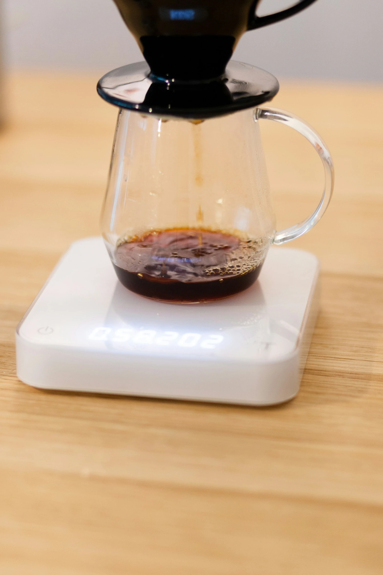 a coffee pot and glass of water on a coaster