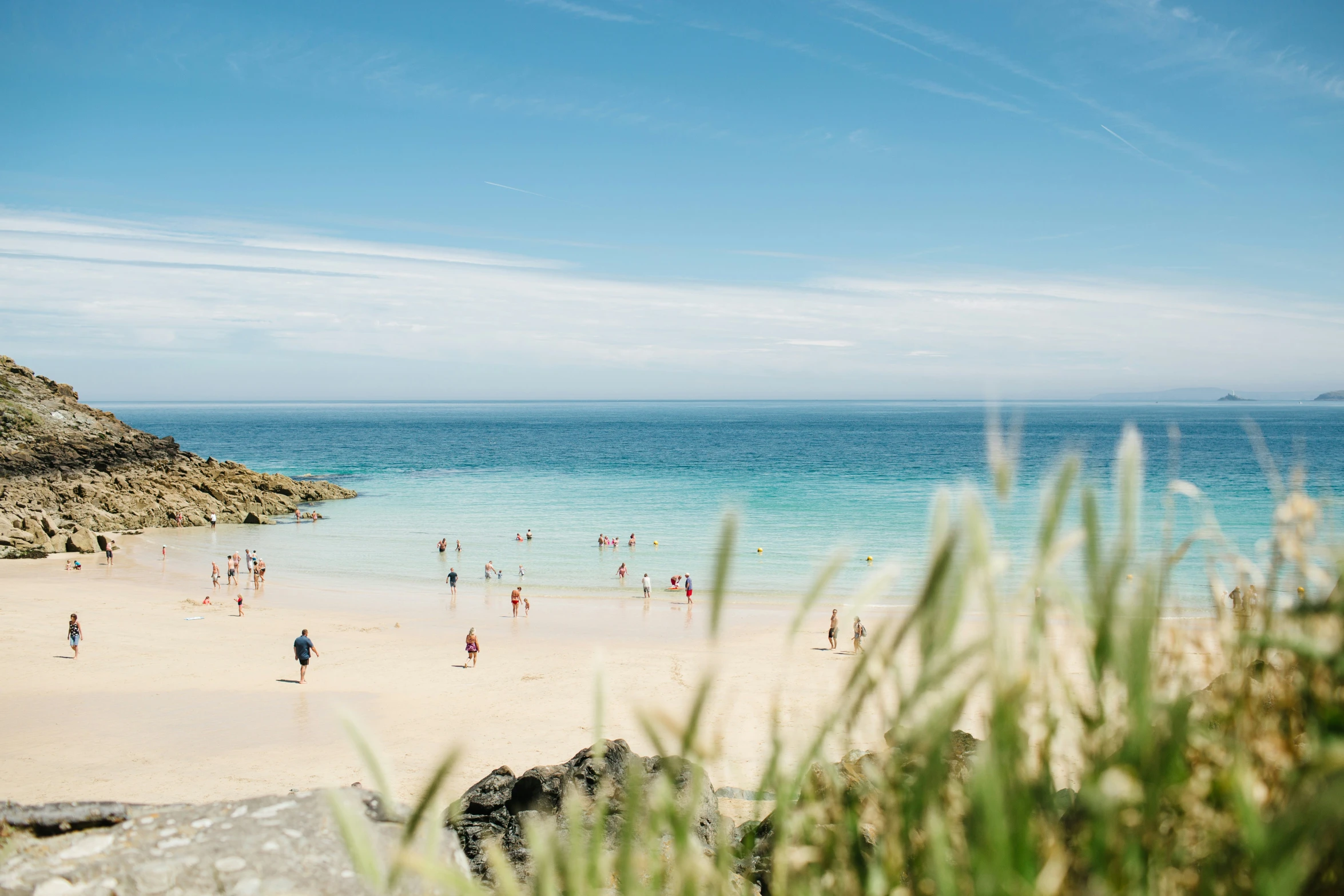 a bunch of people walking down a beach with the water