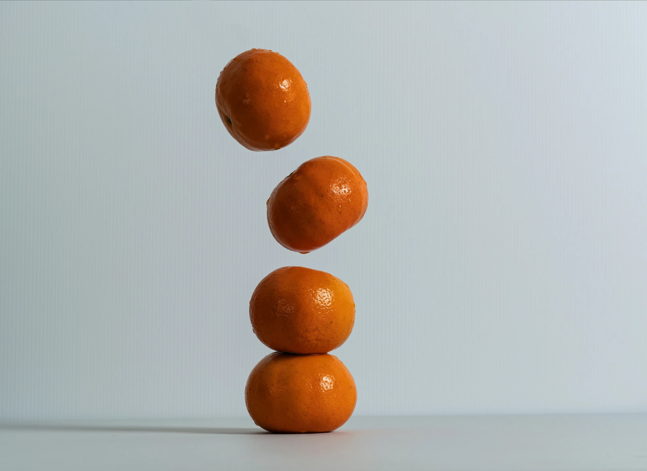 three oranges standing on top of each other