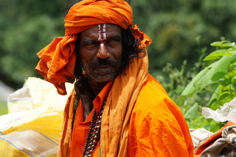 a man wearing a turban standing near tents