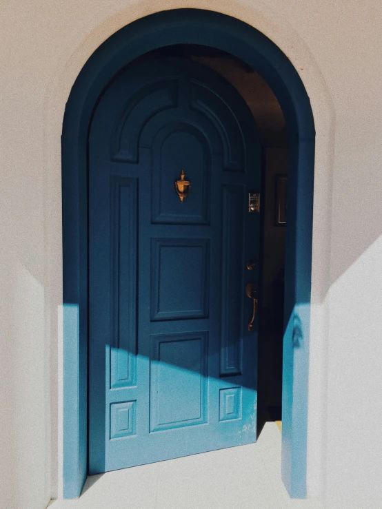 a blue doorway and doorway frame with an arched arch